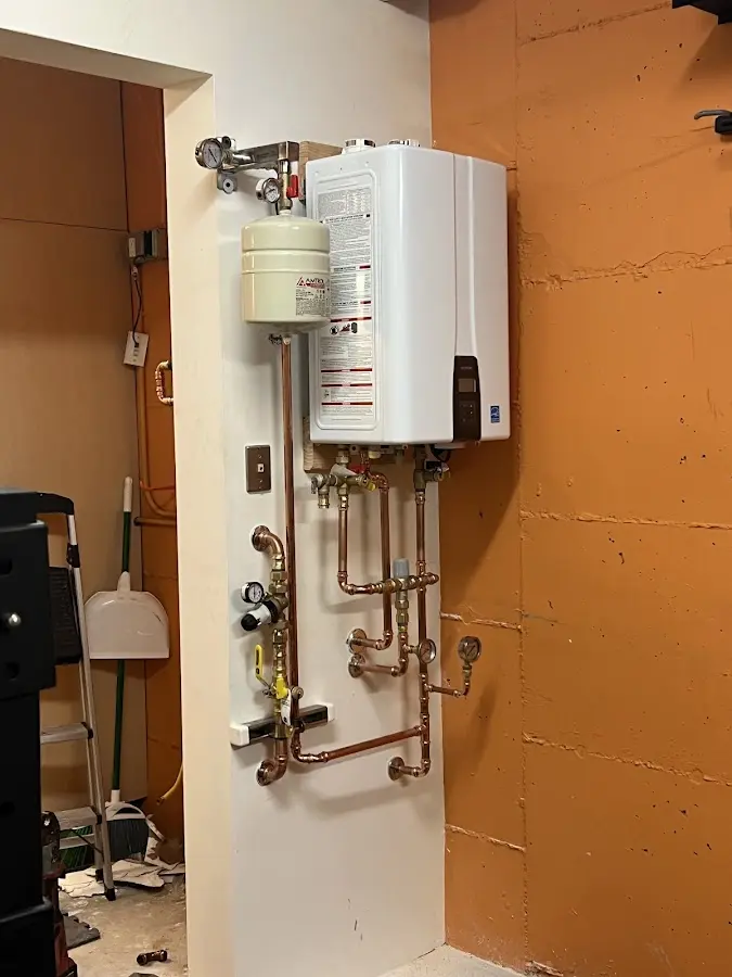 Plumbing technician inspecting water heater connections in Waldorf